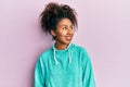 Beautiful african american woman with afro hair wearing casual sweatshirt looking away to side with smile on face, natural Royalty Free Stock Photo