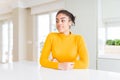 Beautiful african american woman with afro hair wearing a casual yellow sweater smiling looking to the side and staring away Royalty Free Stock Photo