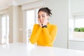 Beautiful african american woman with afro hair wearing a casual yellow sweater Tired hands covering face, depression and sadness,