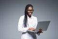 Beautiful African American woman doctor or nurse holding a laptop computer isolated on a gray background Royalty Free Stock Photo
