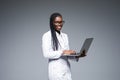 Beautiful African American woman doctor or nurse holding a laptop computer isolated on a gray background Royalty Free Stock Photo