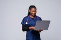 Beautiful African American woman doctor or nurse holding a laptop computer on a white background Royalty Free Stock Photo