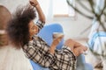 Beautiful African-American woman drinking tea in armchair at home Royalty Free Stock Photo