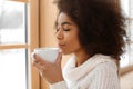Beautiful African-American woman drinking tea near window Royalty Free Stock Photo