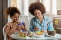 Beautiful African American woman and her daughter coloring Easter eggs Royalty Free Stock Photo