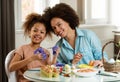 Beautiful African American woman and her daughter coloring Easter eggs Royalty Free Stock Photo