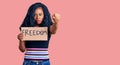 Beautiful african american woman holding freedom banner annoyed and frustrated shouting with anger, yelling crazy with anger and