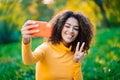 Beautiful african american woman holding and using smart phone to film herself outdoor. Black female using technology Royalty Free Stock Photo