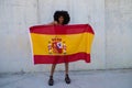 Beautiful african-american woman holds the flag of spain in her arms in a photo shoot for a sports publication. Concept olympic Royalty Free Stock Photo