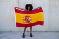 Beautiful african-american woman holds the flag of spain in her arms in a photo shoot for a sports publication. Concept olympic Royalty Free Stock Photo