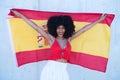 Beautiful african-american woman holds the flag of spain in her arms in a photo shoot for a sports publication. Concept olympic Royalty Free Stock Photo