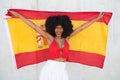 Beautiful african-american woman holds the flag of spain in her arms in a photo shoot for a sports publication. Concept olympic Royalty Free Stock Photo