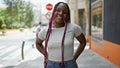 Beautiful african american woman laughing, bringing joy to the city street with her confident smile and casual style, radiating Royalty Free Stock Photo