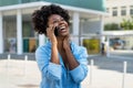Beautiful african american woman laughing and talking with boyfriend at phone Royalty Free Stock Photo