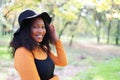 Beautiful african american woman smiling and walking in the park during sunset. Outdoor portrait of a smiling black girl Royalty Free Stock Photo