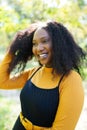 Beautiful african american woman smiling and walking in the park during sunset. Outdoor portrait of a smiling black girl Royalty Free Stock Photo