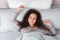 Beautiful African American woman stretching in bed, top view Royalty Free Stock Photo