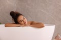 Beautiful African American woman taking bath indoors Royalty Free Stock Photo