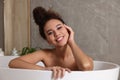 Beautiful African American woman taking bath indoors Royalty Free Stock Photo