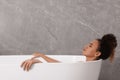 Beautiful African American woman taking bath indoors, space for text Royalty Free Stock Photo