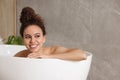 Beautiful African American woman taking bath indoors, space for text Royalty Free Stock Photo