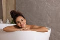 Beautiful African American woman taking bath indoors, space for text Royalty Free Stock Photo