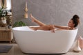 Beautiful African American woman taking bath indoors Royalty Free Stock Photo