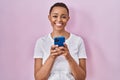 Beautiful african american woman using smartphone smiling with a happy and cool smile on face Royalty Free Stock Photo