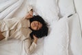 Beautiful African American woman waking up in her bed. Royalty Free Stock Photo