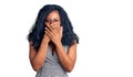 Beautiful african american woman wearing business dress and glasses shocked covering mouth with hands for mistake Royalty Free Stock Photo