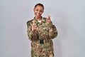 Beautiful african american woman wearing camouflage army uniform pointing fingers to camera with happy and funny face Royalty Free Stock Photo