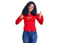 Beautiful african american woman wearing casual clothes success sign doing positive gesture with hand, thumbs up smiling and happy Royalty Free Stock Photo