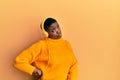 Beautiful african american young woman with short hair wearing headphones listening to music and dancing over isolated yellow Royalty Free Stock Photo