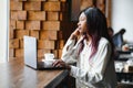 Beautiful african business woman waiting for the meeting in a co-working space and sitting with the portable computer. Hipster Royalty Free Stock Photo