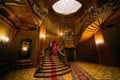 Beautiful african couple going down on vintage stairs. Luxurious theatre interior background Royalty Free Stock Photo