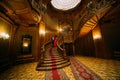 Beautiful african couple going down on vintage stairs. Luxurious theatre interior background Royalty Free Stock Photo