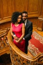 Beautiful african couple posing on the vintage stairs. Luxurious theatre interior background