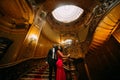 Beautiful african couple posing on the vintage stairs. Luxurious theatre interior background