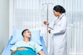 Beautiful african doctor taking care of cacausian teen patient on bed at hospital Royalty Free Stock Photo