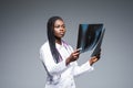 Beautiful african doctor woman with X-ray of lungs, fluorography, roentgen on gray background. Healthcare personnel,