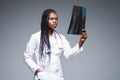 Beautiful african doctor woman with X-ray of lungs, fluorography, roentgen on gray background. Healthcare personnel,