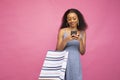 Beautiful African female posting in social media using her smartphone about her shopping spree