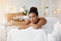 Beautiful african girl looking at camera resting relaxing in spa salon. Copy space.