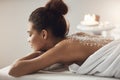 Beautiful african girl resting relaxing with sea salt on back in spa salon. Royalty Free Stock Photo