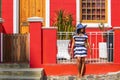 A beautiful African woman in a blue and white striped dress sightseeing in and around the traditional houses of Bo-Kaap, Cape Town