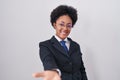 Beautiful african woman with curly hair wearing business jacket and glasses smiling cheerful offering palm hand giving assistance Royalty Free Stock Photo