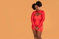 Beautiful african Woman posing in red mini dress, looking at the camera. Afro hairstyle, glamour makeup