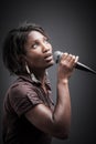 Beautiful African woman singing with the microphone Royalty Free Stock Photo