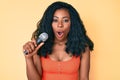 Beautiful african woman singing song using microphone scared and amazed with open mouth for surprise, disbelief face Royalty Free Stock Photo