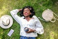 Beautiful african woman smiling while lying on the grass. Royalty Free Stock Photo